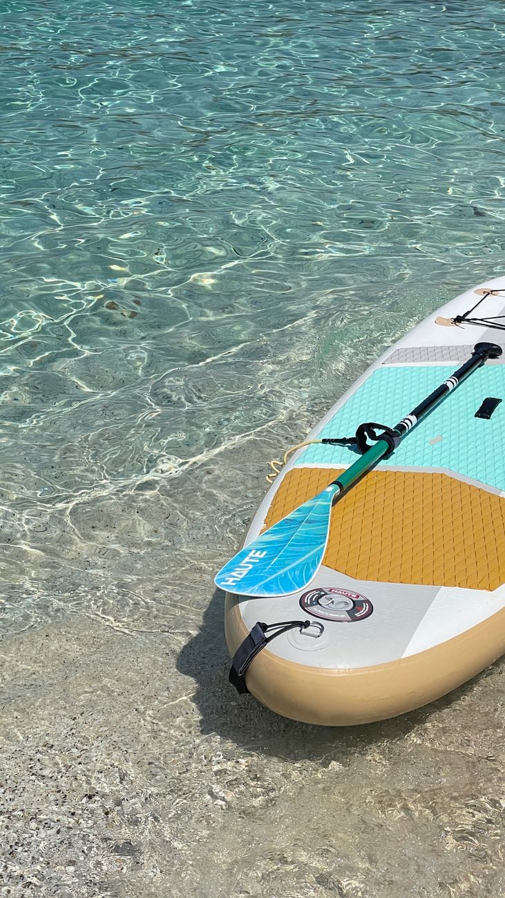 a paddle board in the water with a blue and yellow stripe